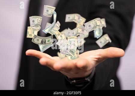 Businessman holding a 3D render of floating dollar banknotes Stock Photo