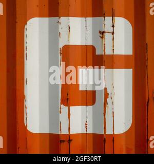 Grunge single letter G on an orange corrugated enameled metal background Stock Photo