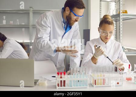 Young medical staff in special clothes are conducting research Stock Photo