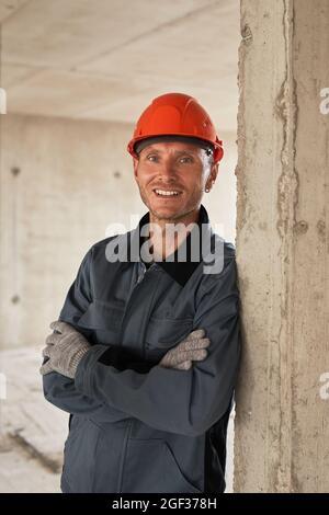 Vertical waist up portrait of smiling construction worker wearing hardhat Stock Photo