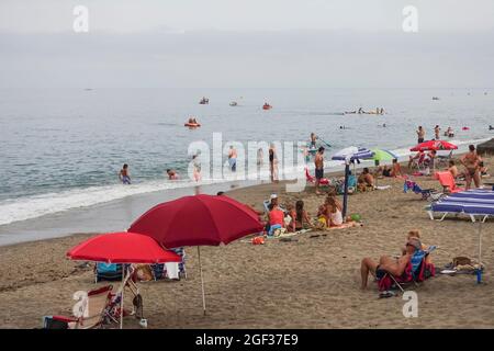 Busy beach in summer at Fuengirola, on a clouded day, during pandemic crisis, Costa del Sol, Spain. Stock Photo