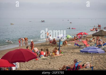 Busy beach in summer at Fuengirola, on a clouded day, during pandemic crisis, Costa del Sol, Spain. Stock Photo