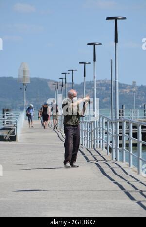 tourist takes a photo on a pier at Trasimeno lake Stock Photo