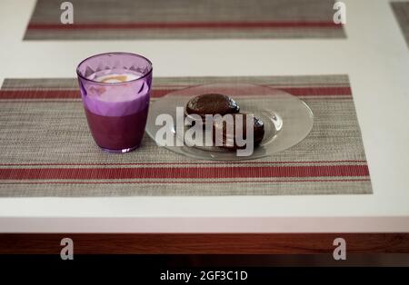 Two chocolate sandwich biscuits on plate and coffee. Tasty breakfast Stock Photo