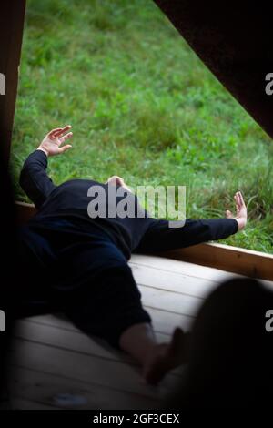 solo dancer move laying on the floor in contemporary improvisation performance on nature bg Stock Photo