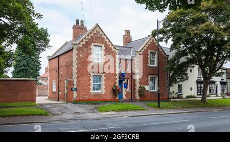 A rural Police Station at Sedgefield,Co.Durham,England,UK with a colourful display of flowers decorating the exterior Stock Photo