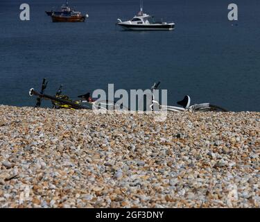 Bikes seen laying on the gravel beach in the UK in summer 2021. Stock Photo
