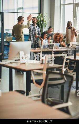 Young men and women feeling cheerful and celebrating work victories Stock Photo