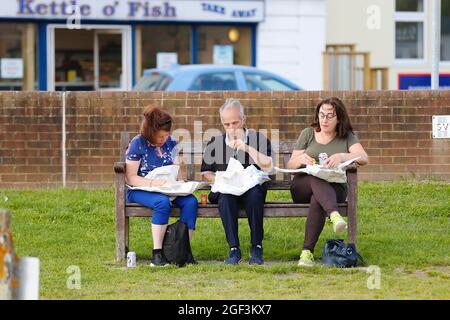 Rye, East Sussex, UK. 23 Aug, 2021. UK Weather: Sunny day in the historic town of Rye with visitors enjoying the fine and dry weather. A family sitting on a bench by the quay eating fish and chips. Photo Credit: Paul Lawrenson /Alamy Live News Stock Photo