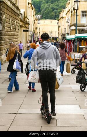 Bath, England - August 2021: Person riding through a pedestrianised area on an e-scooter in the city centre Stock Photo