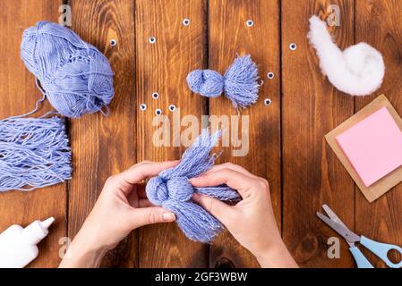 How to make a cute thread bird for decoration. Children's art project. DIY concept. Hands are made from blue threads of a blue dove. Step-by-step phot Stock Photo