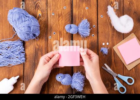 How to make a cute thread bird for decoration. Children's art project. DIY concept. Hands are made from blue threads of a blue dove. Step-by-step phot Stock Photo