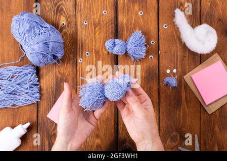 How to make a cute thread bird for decoration. Children's art project. DIY concept. Hands are made from blue threads of a blue dove. Step-by-step phot Stock Photo