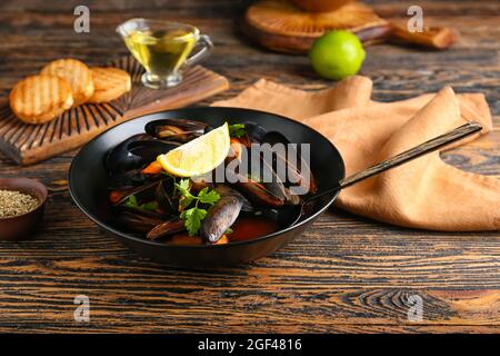 Plate with tasty Mussels Marinara on wooden background Stock Photo