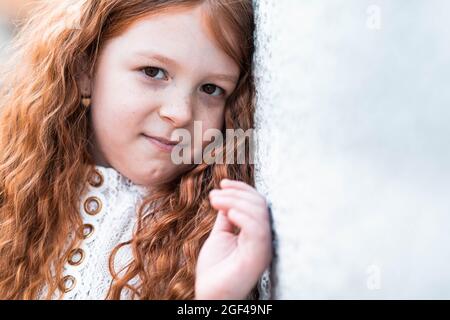 Shy little ginger girl, kid with red hair looking modest touching two ...