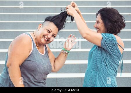 Two adult twin sisters playing with each other Stock Photo