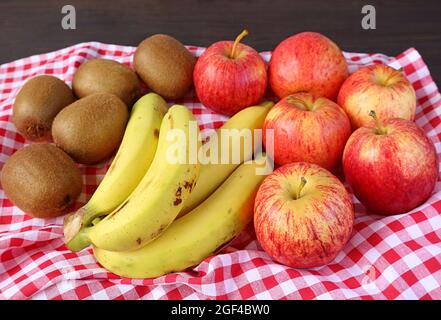 Pile of Fresh Ripe Assorted Fruits on Checkered Table Cloth for the Concept of WELLNESS Stock Photo