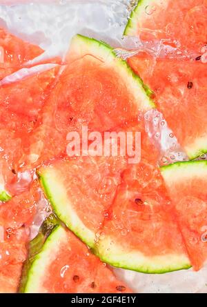 Close-up fresh slices of red melon on white background. Slices of melon in sparkling water on white background, close-up. Copy space. Stock Photo