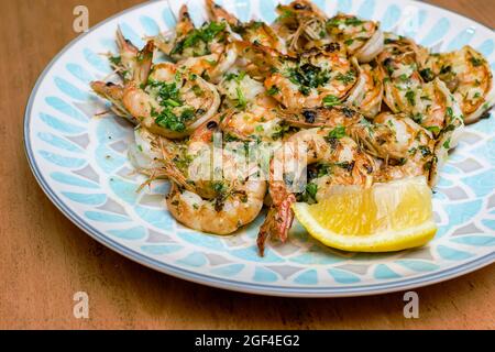 Fresh grilled shrimps served on a plate with lemon Stock Photo