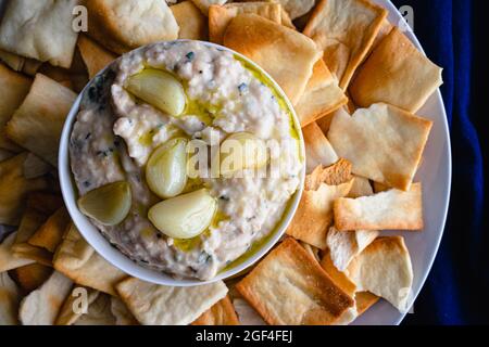 Roasted Garlic and Rosemary White Bean Dip: Dip made from cannellini beans, olive oil, and roasted garlic served with pita chips Stock Photo
