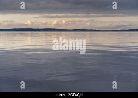 Beautiful autumn misty grey lake and cloudy sky reflection in the water at sunset. Dark and moody nature background. Great wallpaper design. Copy space. Stock Photo