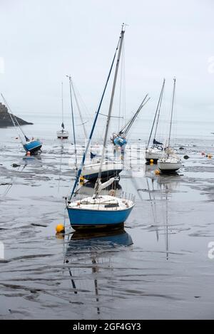 Small boats resting in the mud at low tide in Granton Harbour on the Firth of Forth, Edinburgh, Scotland, UK. Stock Photo