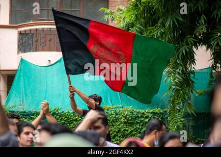 A young Afghan protester, waves the Afghanistan flag during a protest in front of UNHCR office at Vasant Vihar, New Delhi.Hundreds of Afghan refugees staged a demonstration in front of the United Nation High Commissioner for refugees (UNHCR) office at Vasant Vihar, New Delhi. The Afghan community demanded access to basic facilities like education and jobs in India or other countries in the world. A large number of desperate Afghan citizens are coming to India following the takeover of the war-torn country by the Taliban. (Photo by Pradeep Gaur/SOPA Images/Sipa USA) Stock Photo