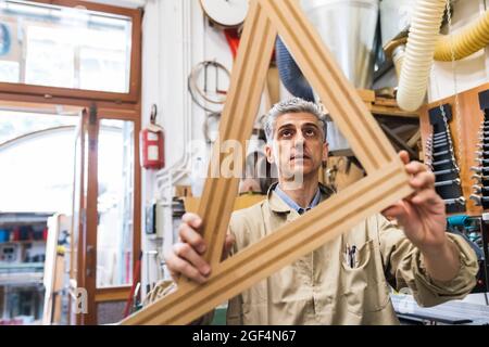 Mature male carpenter working with wood in workshop Stock Photo