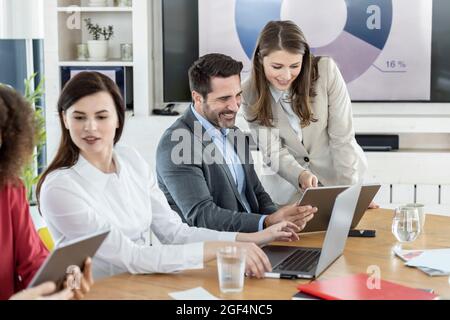 Professional team using digital tablet while working in meeting at office Stock Photo