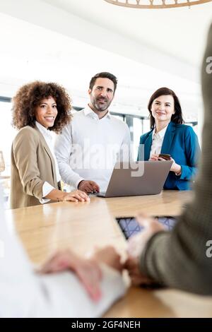 Businessman and businesswomen looking at colleagues discussing strategy during meeting in office Stock Photo