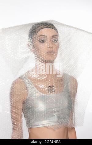 Cyborg woman covered with bubble wrap plastic against white background Stock Photo