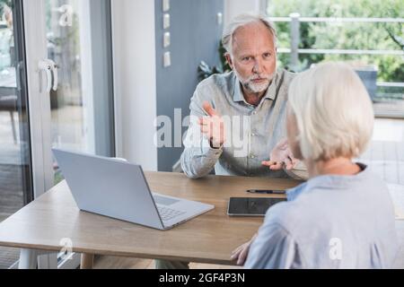 Male and female professionals discussing with each other at desk in home office Stock Photo