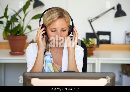 Female customer service representative wearing headphones at office Stock Photo
