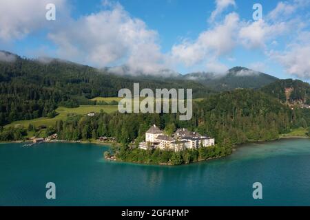 Austria, Salzburg, Hof bei Salzburg, Drone view of Schloss Fuschl standing on forested shore of Lake Fuschl Stock Photo