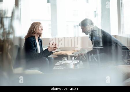 Male and female professionals discussing while sharing ideas in cafe Stock Photo