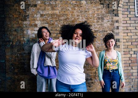 Young woman with curly black hair standing in front of friends Stock Photo