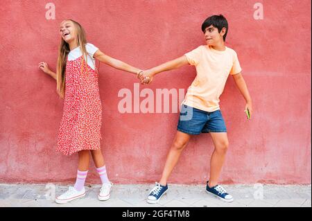Boy and girl using smart phone while standing in city Stock Photo