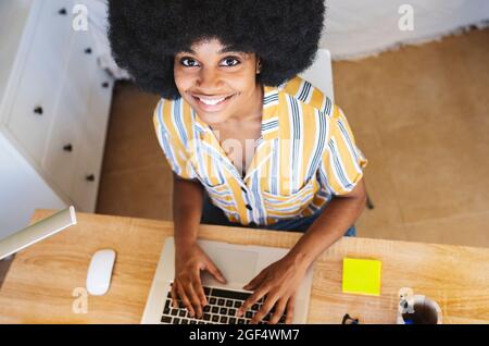 Smiling young woman sitting at desk Stock Photo