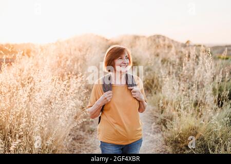 Smiling senior woman looking away while hiking Stock Photo