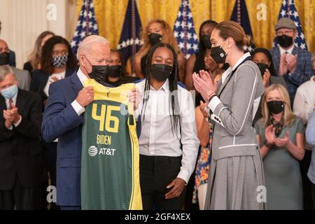 Washington, United States. 23rd Aug, 2021. President Joe Biden is given a team jersey Jewell Loyd, center and Breanna Stewart, right, of the Seattle Storm after they won the 2020 WNBA Championship at the White House in Washington, DC on Monday, August 23, 2021. Photo by Ken Cedeno/Pool/Sipa USA Credit: Sipa USA/Alamy Live News Stock Photo