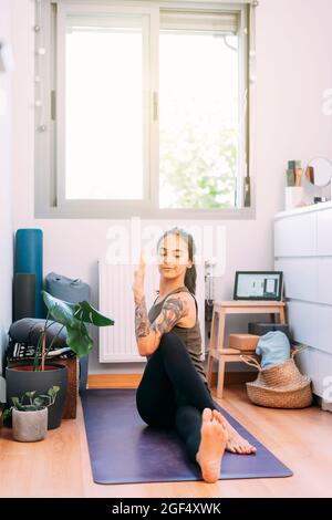 Mid adult woman practicing yoga at home Stock Photo