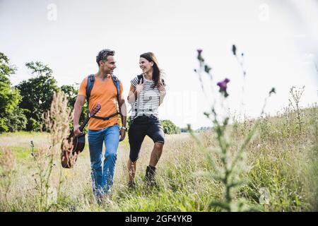 Smiling couple hiking together on grass Stock Photo