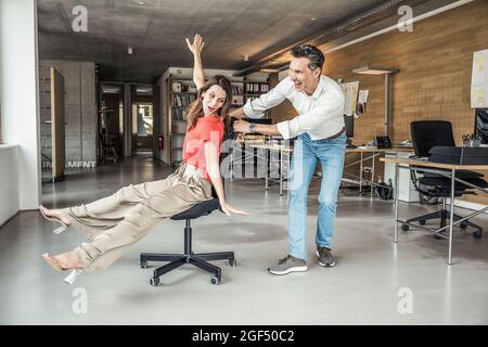 Male and female colleague having fun while playing in office Stock Photo