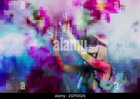 Woman wearing virtual reality simulator gesturing over multi-colored pixelated background Stock Photo