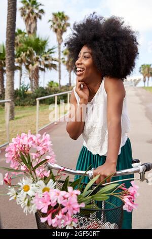 Happy woman with bicycle standing on road Stock Photo