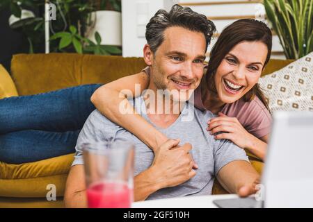 Happy couple using digital tablet at home Stock Photo