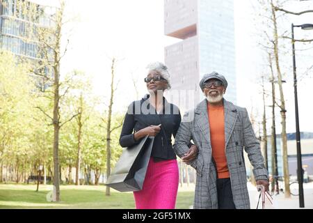 Smiling couple holding shopping bags while walking in city Stock Photo