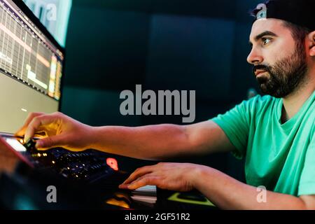 Mid adult male composer using sound mixer in studio Stock Photo