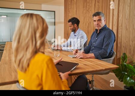 Male and female colleagues discussing during meeting at office Stock Photo