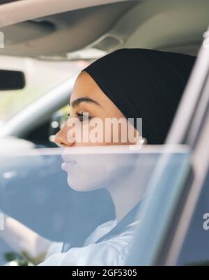 Woman looking through window while sitting in car Stock Photo